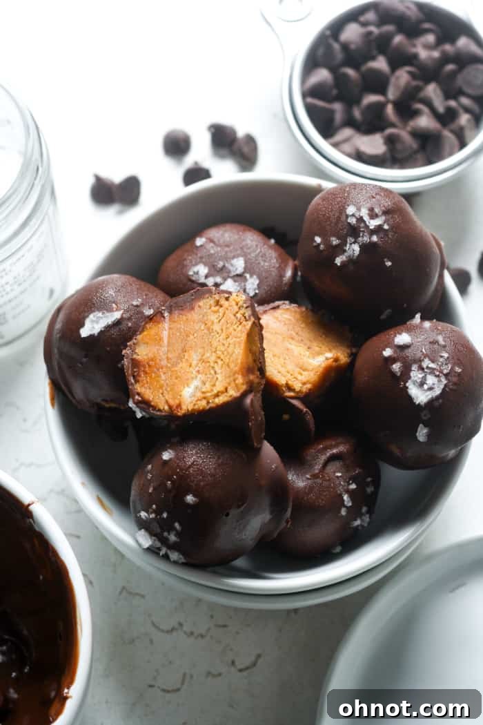 A stack of chocolate-coated peanut butter balls with a light drizzle.