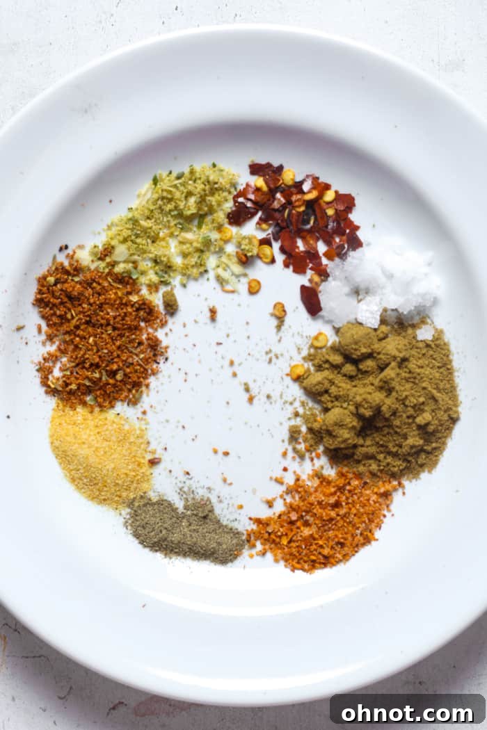 A collection of vibrant spices laid out on a white plate, ready for mixing.