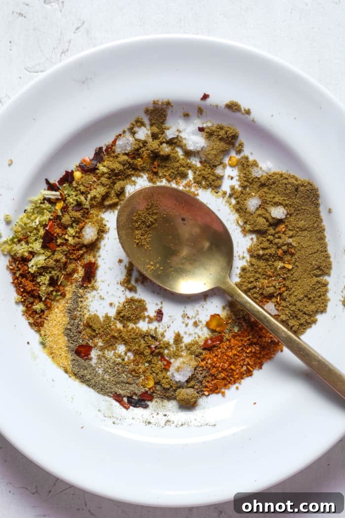 Close-up of a vibrant blend of spicy seasonings in a bowl with a spoon.