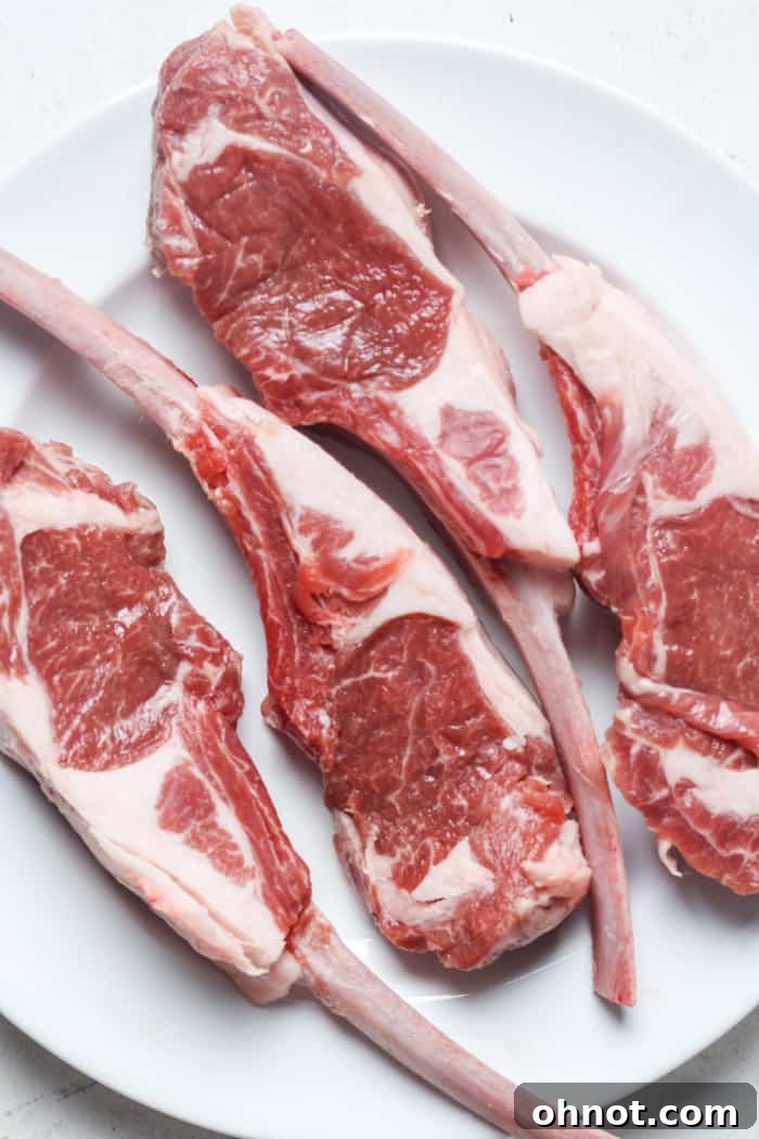 A plate of golden-brown lamb lollipops, ready to be served, with fresh herbs.