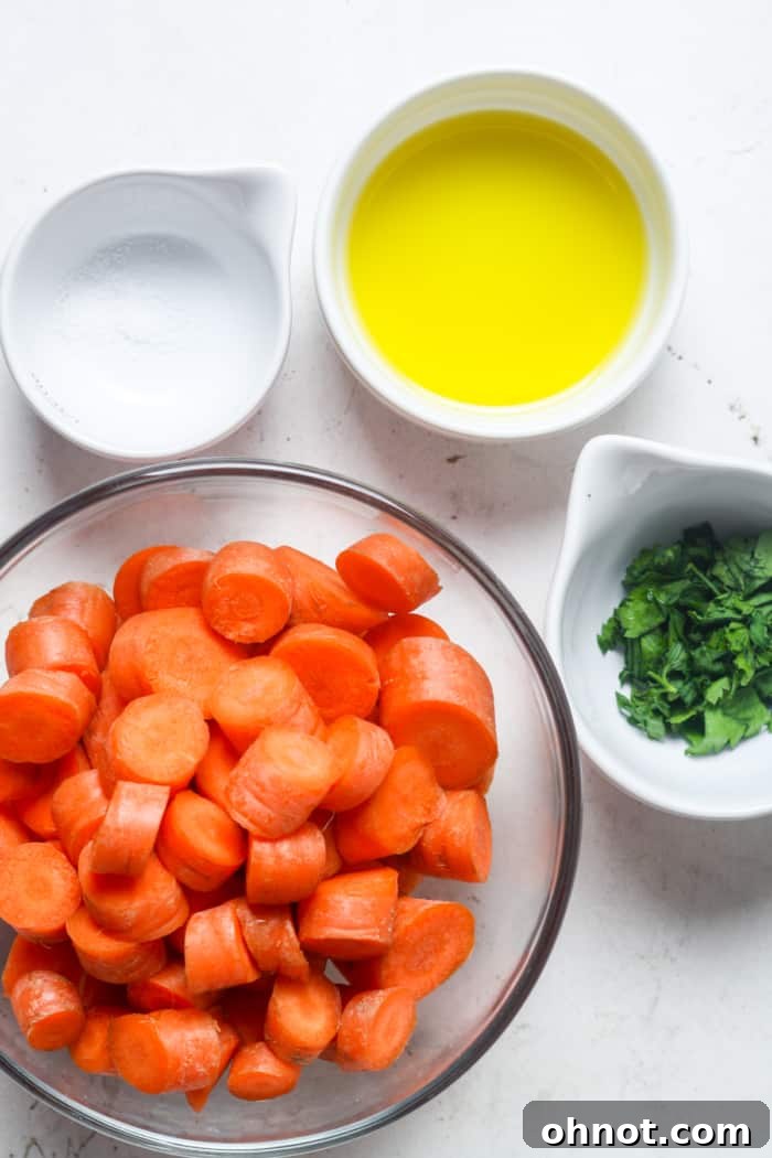 Fresh ingredients laid out for making sauteed carrots, including whole carrots, olive oil, and sea salt.