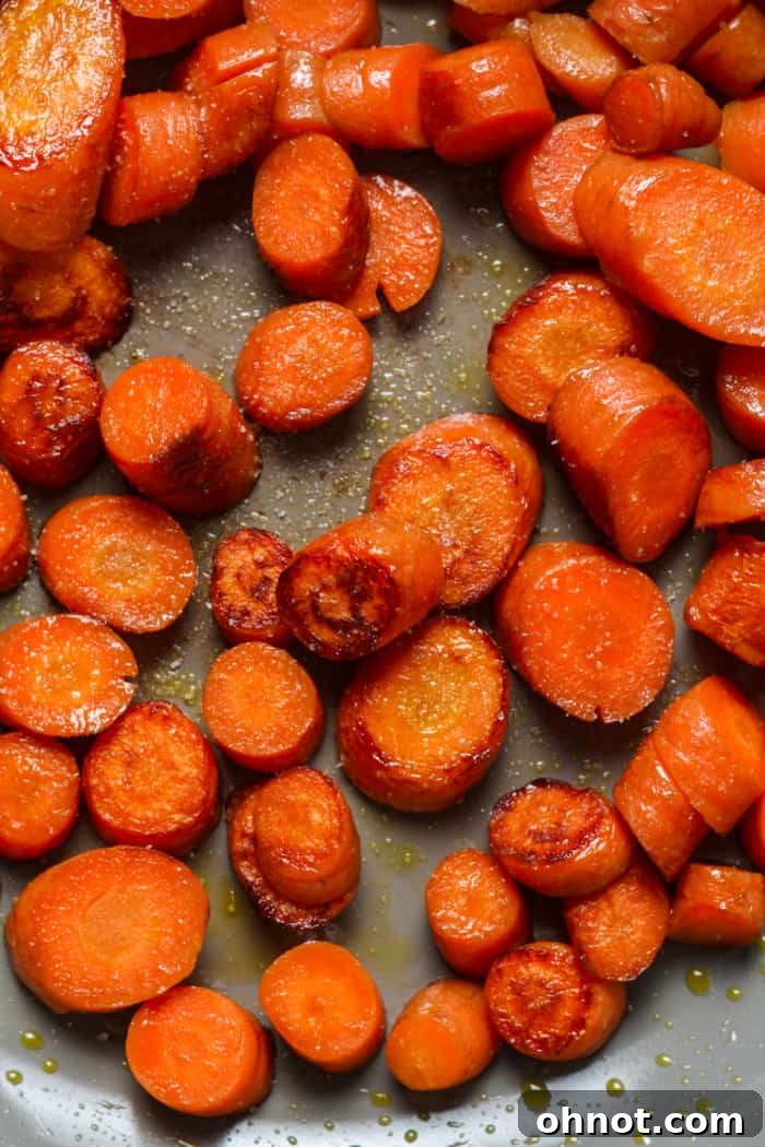 Sauteed carrots seasoned with sea salt in a pan.