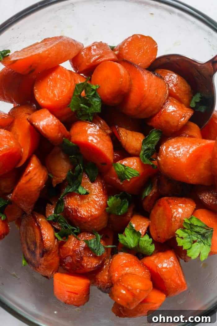 A bowl of freshly sauteed carrots garnished with green herbs.