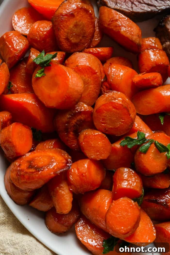 A serving of sauteed carrots garnished with fresh herbs in a white bowl.