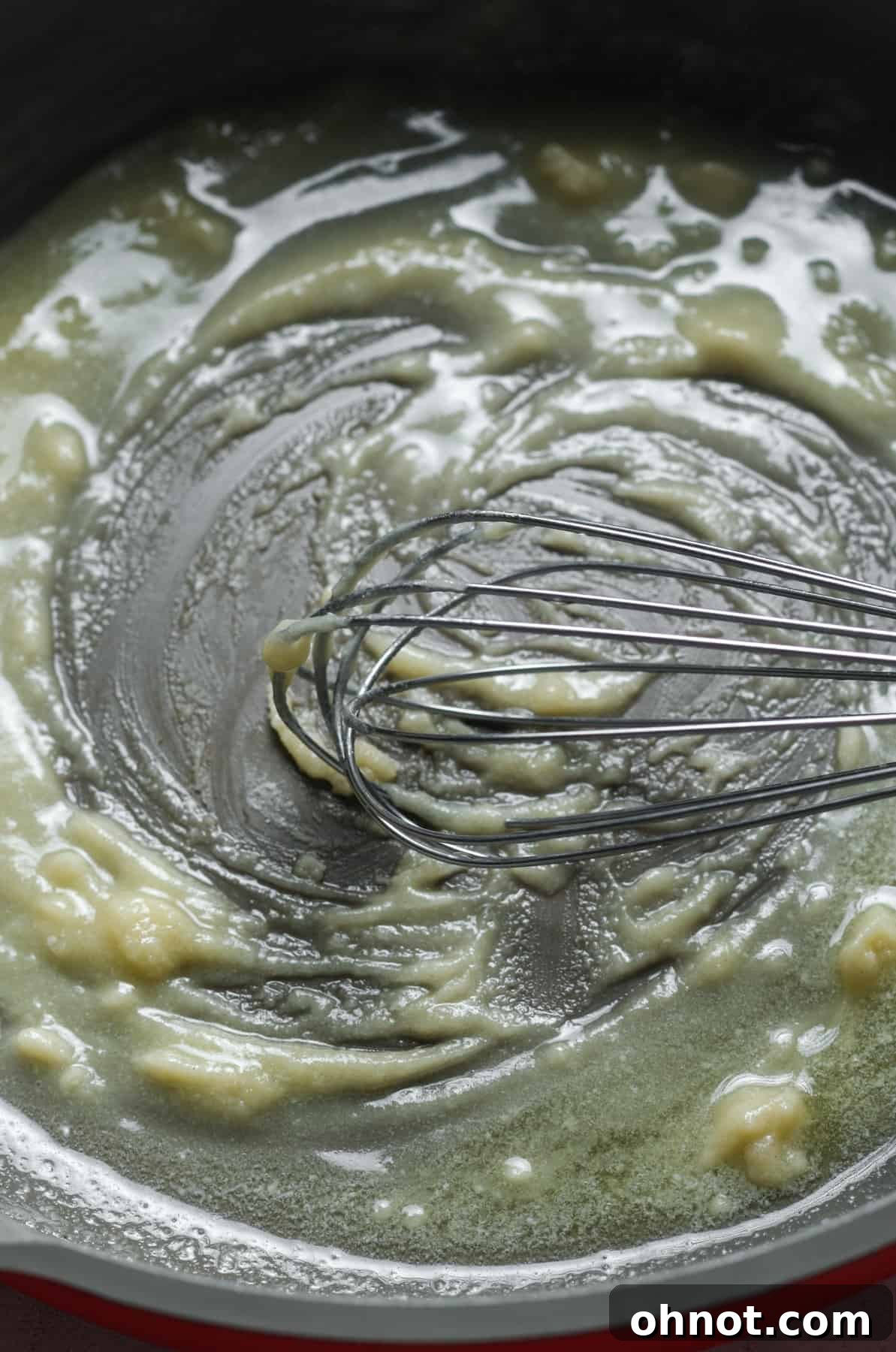 A thick, pale flour slurry bubbling gently in a skillet, indicating a perfectly cooked roux.
