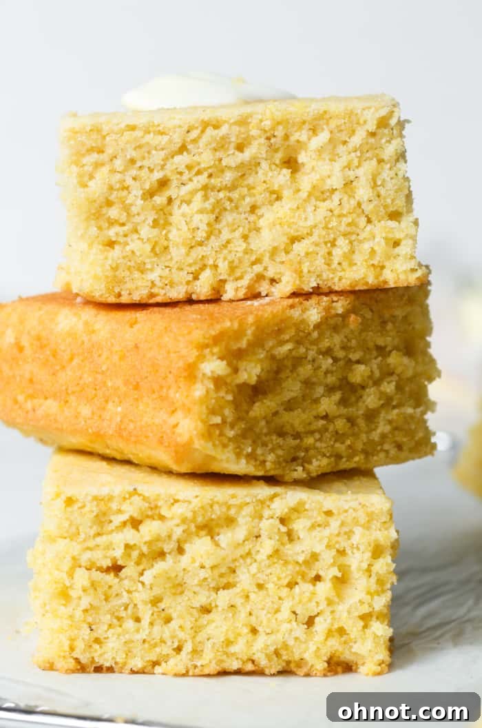 A stack of golden, freshly baked gluten-free cornbread squares, showcasing their soft interior and perfect texture, ready to be enjoyed.