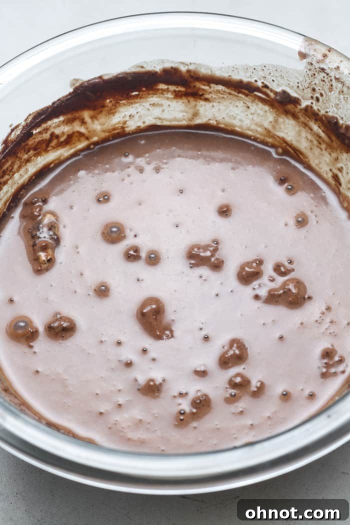 Smooth, watery brownie batter in a mixing bowl, showcasing the consistency after adding milk.
