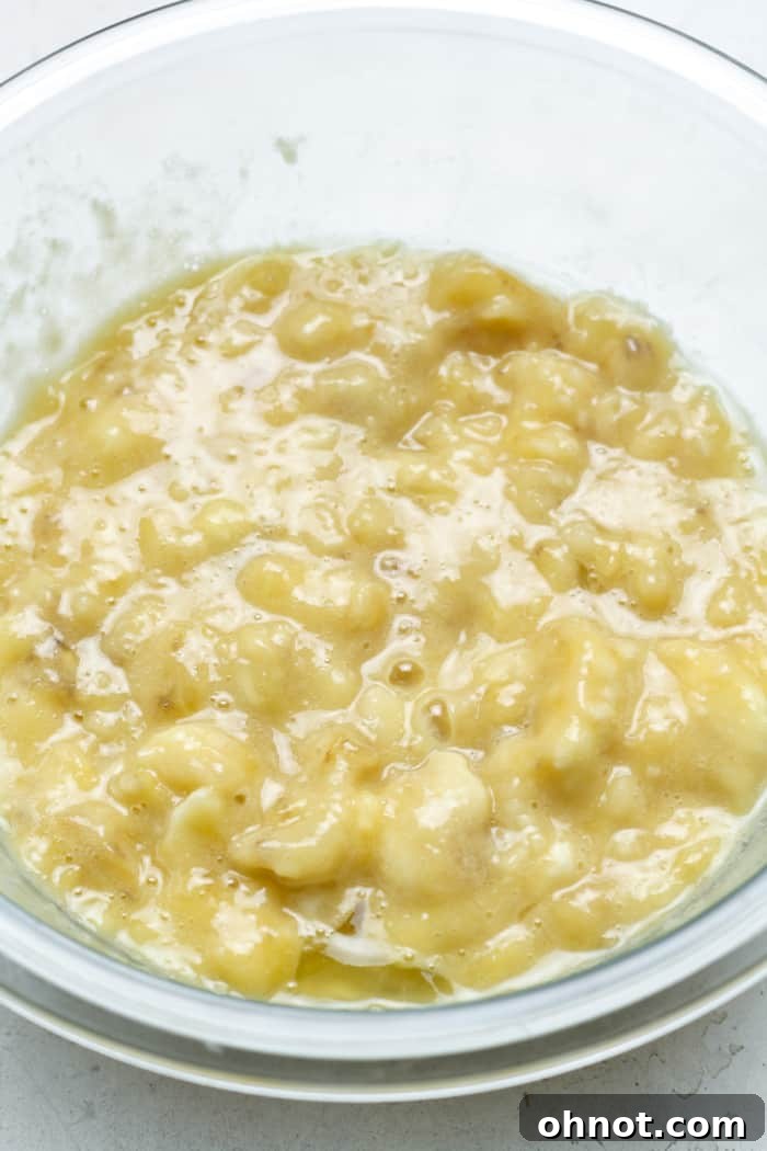 Mashing ripe bananas in a bowl.