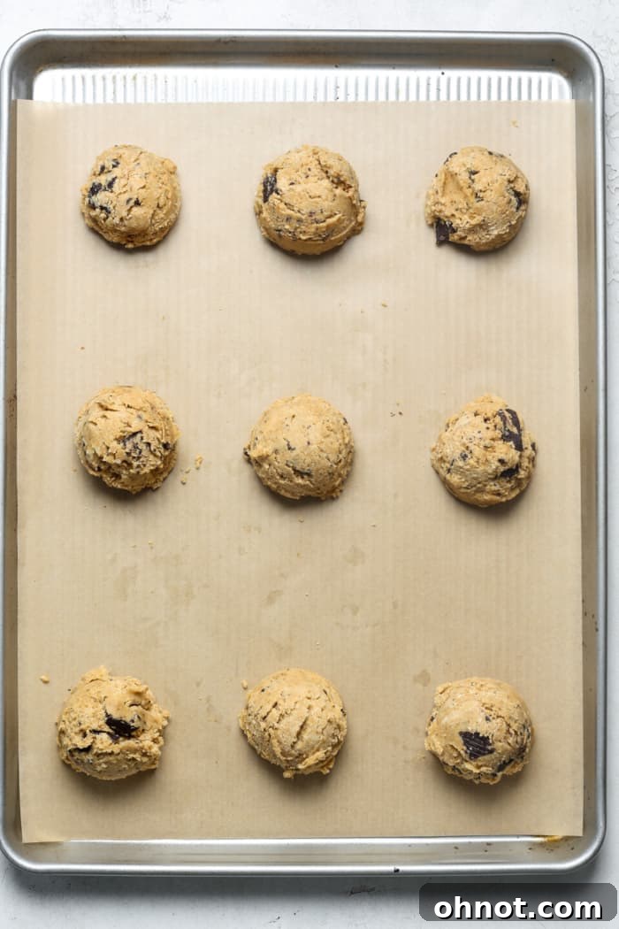 Dough balls scooped onto a parchment-lined cookie sheet.