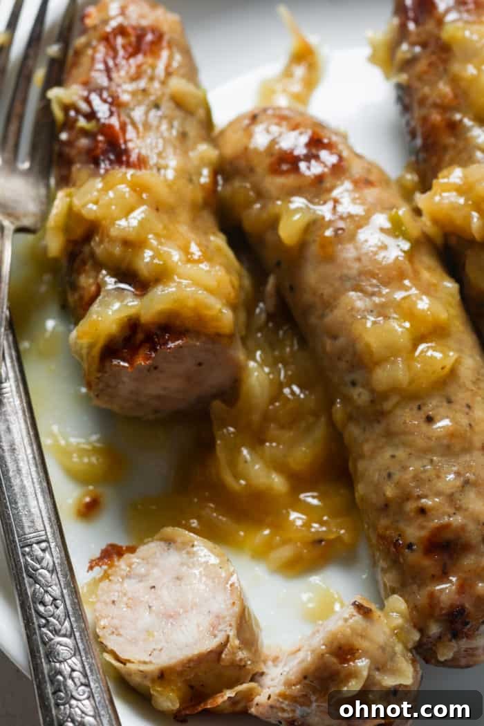 Plated German bratwurst and onions with traditional sides.