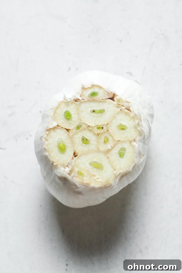 Garlic bulb with skin peeled away, cloves separated for mincing.