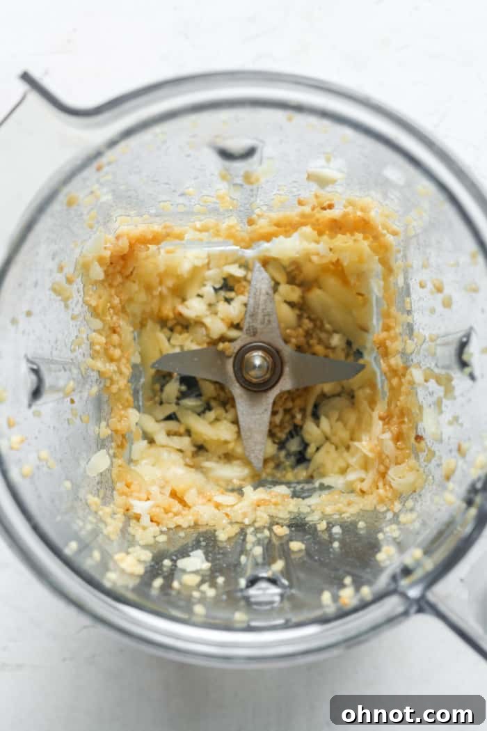 Garlic being actively minced in a blender, showing the process.