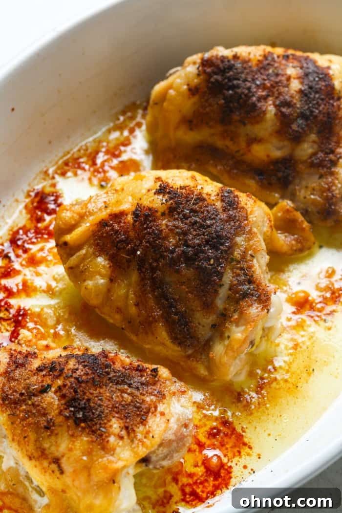 Oven-baked chicken thighs, golden and crispy, fresh out of the oven.