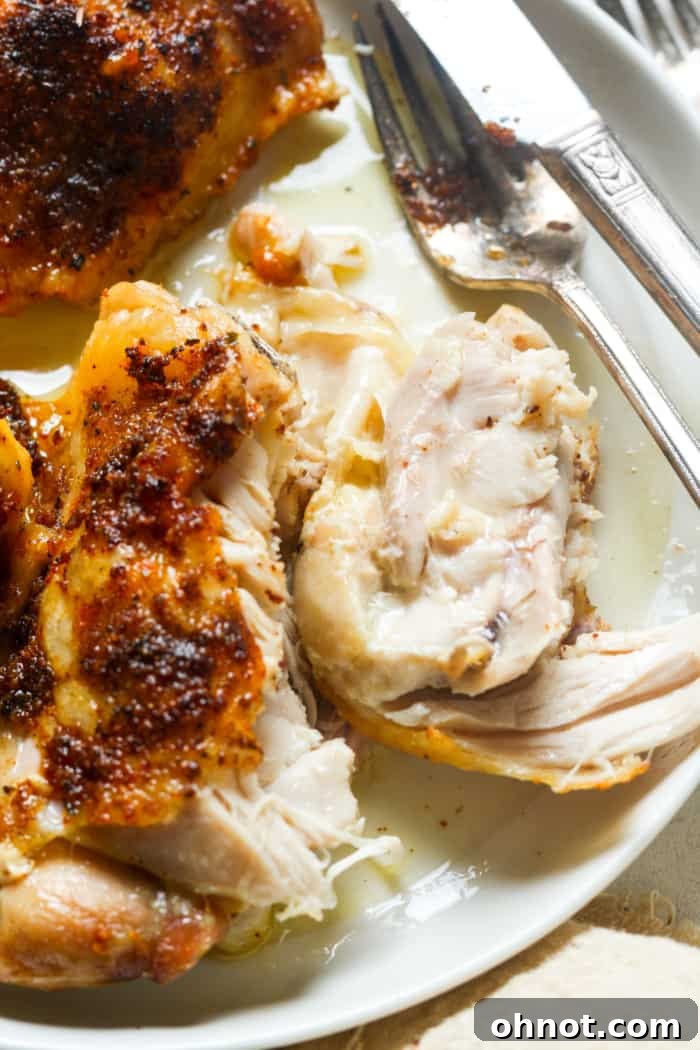 Close-up of a perfectly cooked chicken thigh, showing its tender, juicy meat.