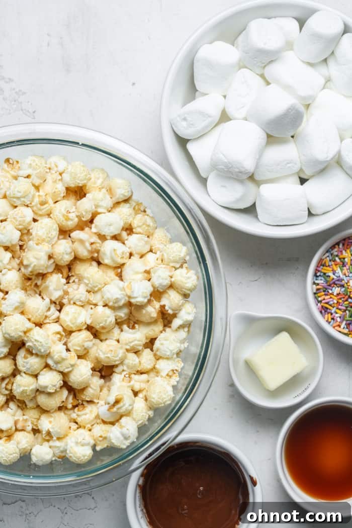 A selection of fresh ingredients laid out for making popcorn bars, including popcorn, marshmallows, and butter.