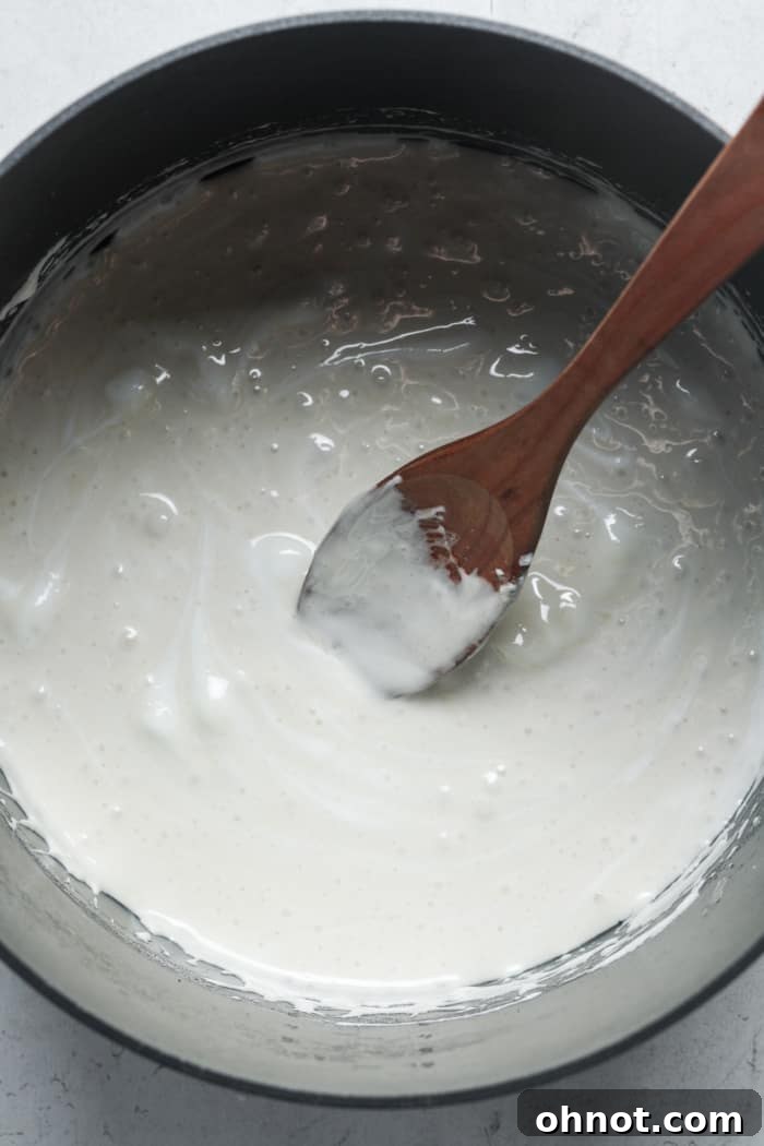 Fully melted marshmallows and butter mixture, smooth and gooey, in a pan.