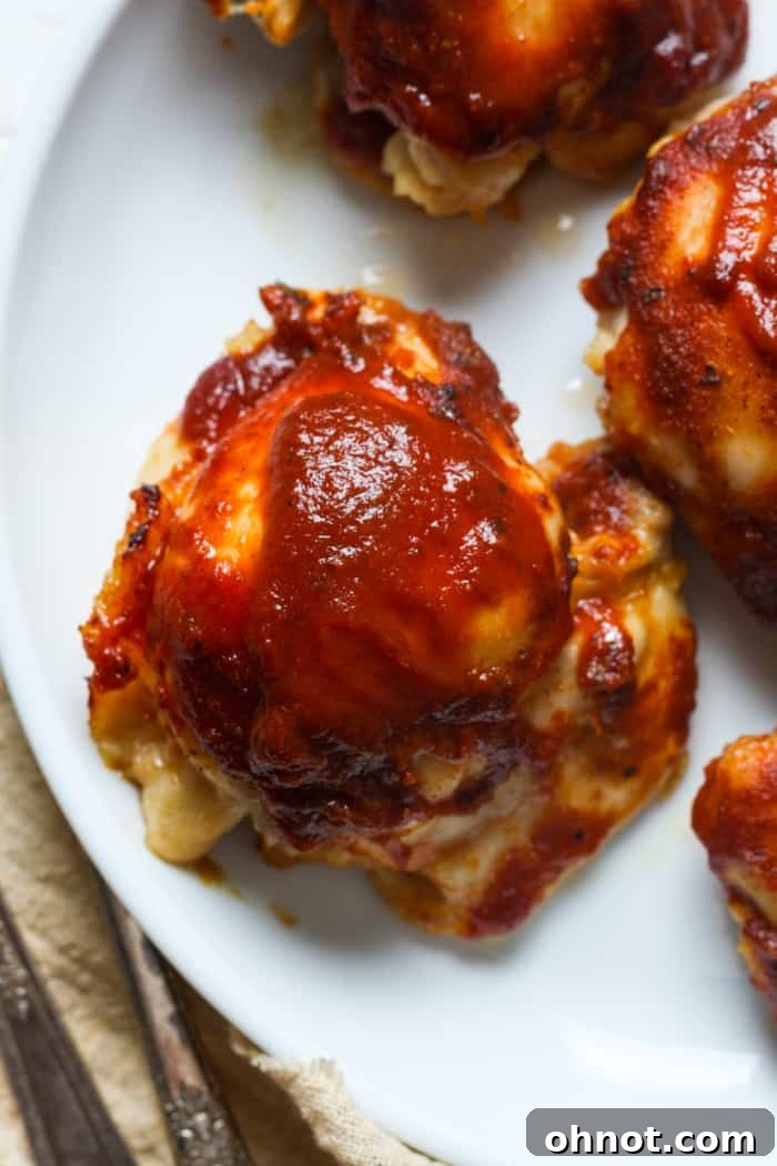 White plate showcasing cooked BBQ chicken thighs.