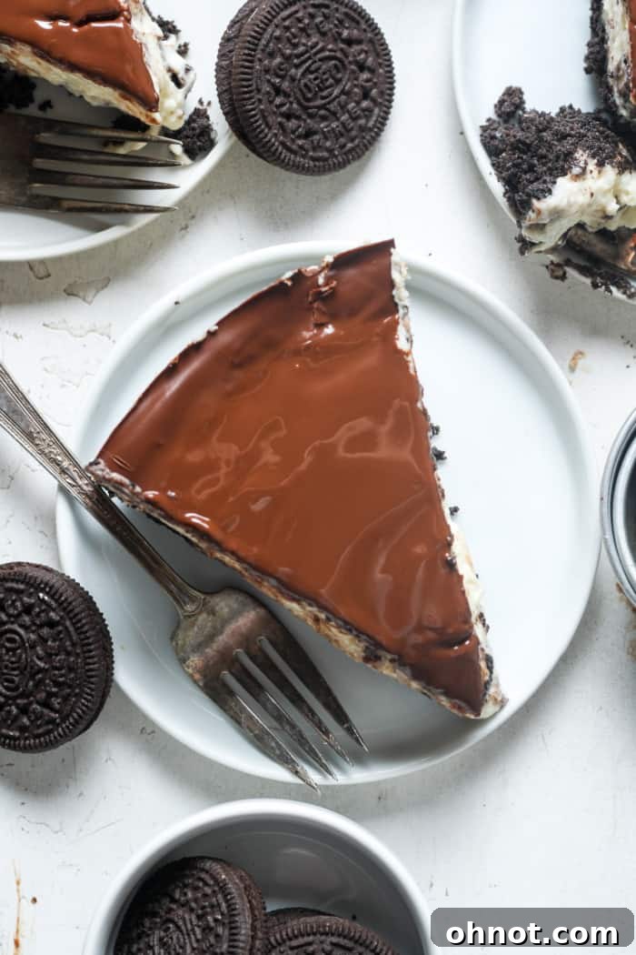 A perfect slice of Oreo cheesecake, showcasing the layered crust, creamy filling, and smooth chocolate ganache topping.