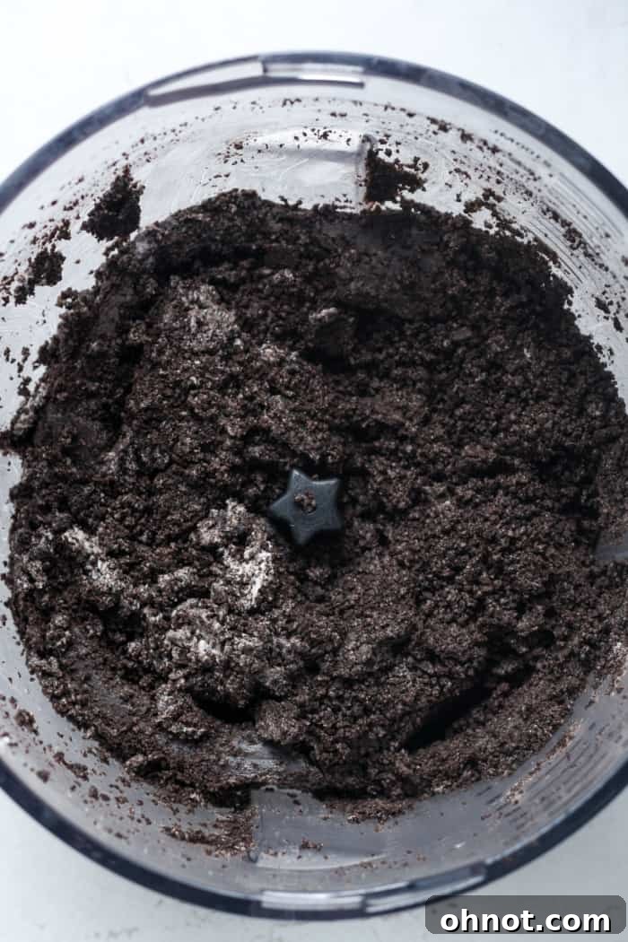 Finely crushed Oreo crumbs, perfectly processed for the cheesecake crust, in a food processor.