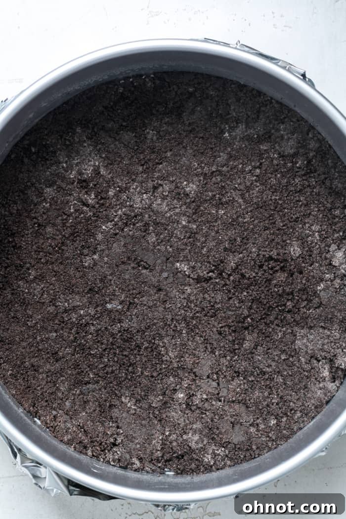 A perfectly formed Oreo cookie crust pressed into a springform pan, ready for the filling.