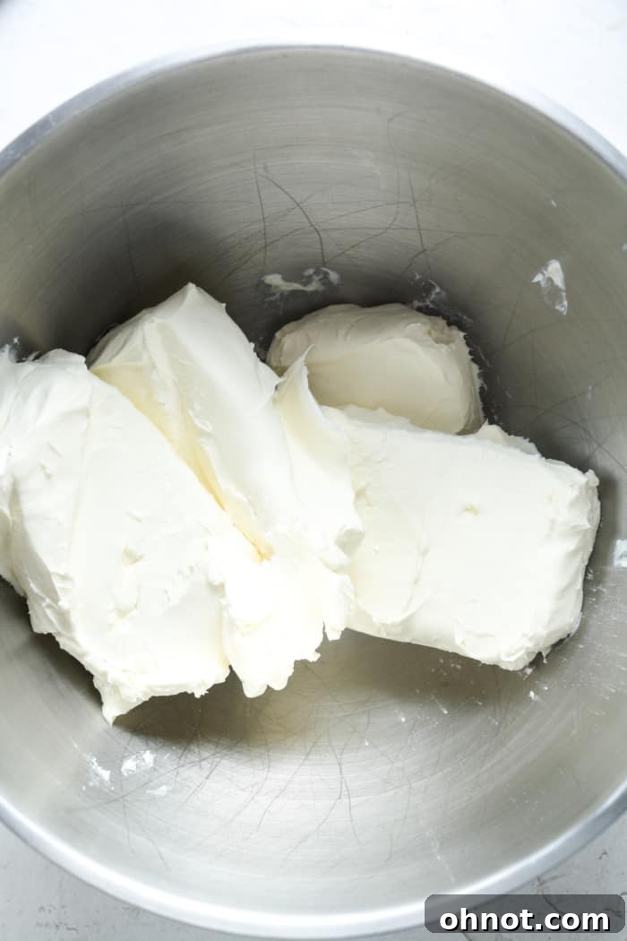 Softened room-temperature cream cheese in a mixing bowl, ready to be beaten for the cheesecake filling.