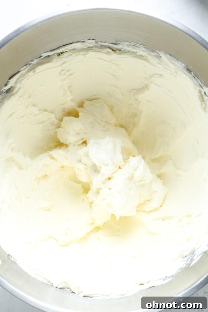 Smooth and fluffy whipped cream cheese in a stand mixer, a perfect base for the cheesecake filling.