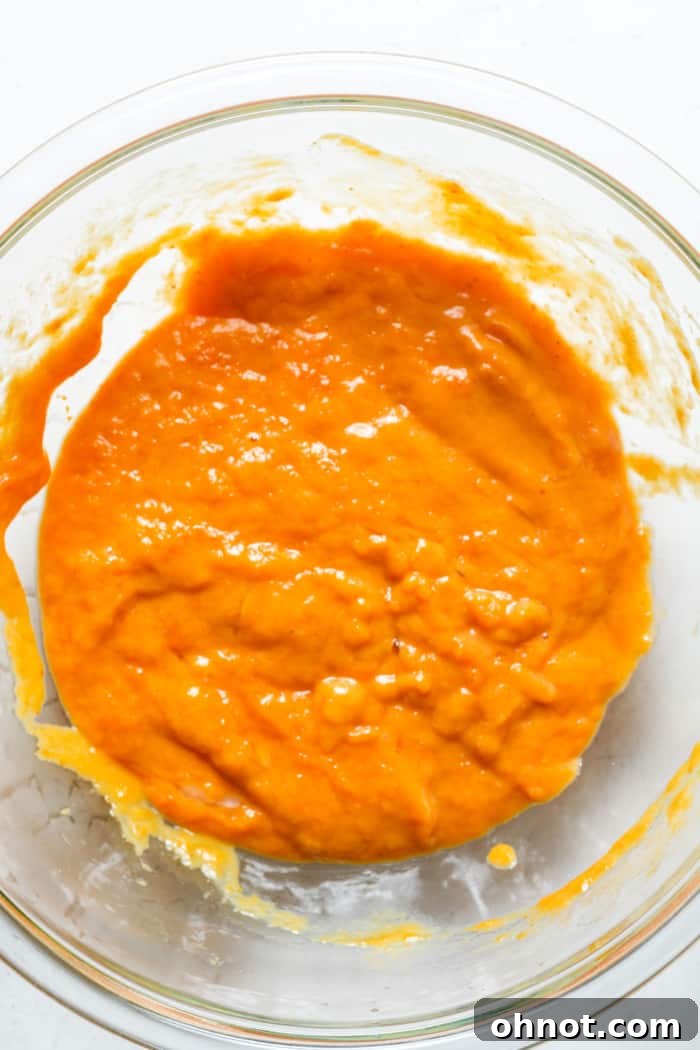 Pumpkin batter in bowl being stirred.