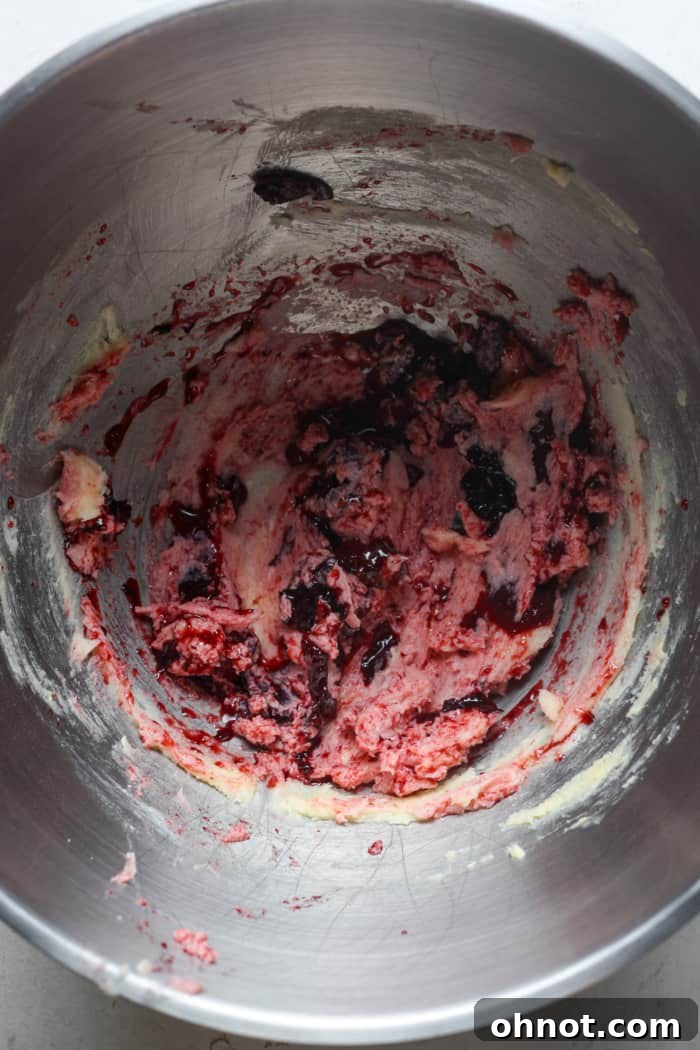 Dark red cookie dough with cherry pieces.