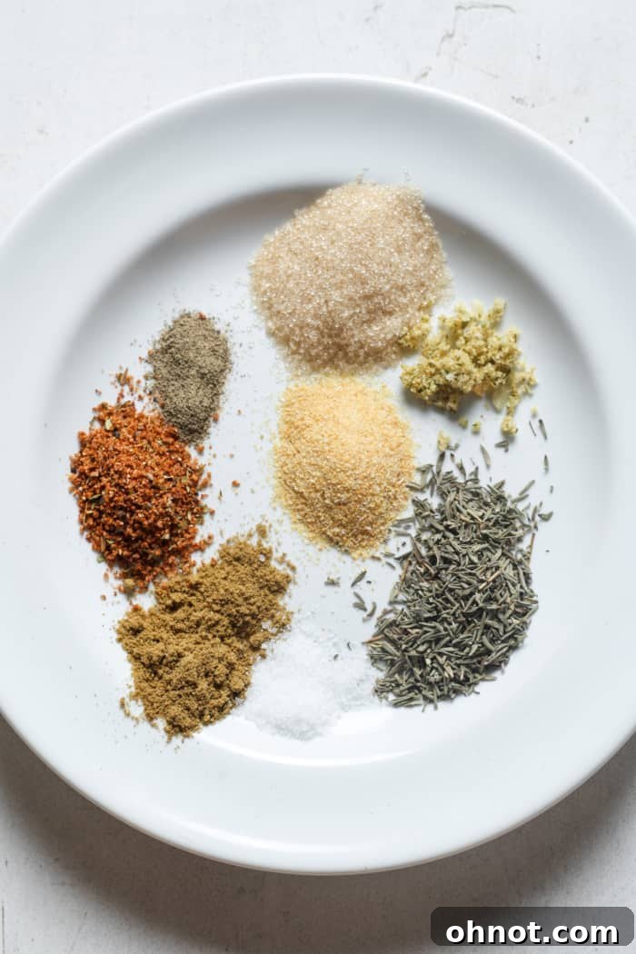 Assorted spices on a white plate, ready for blending.