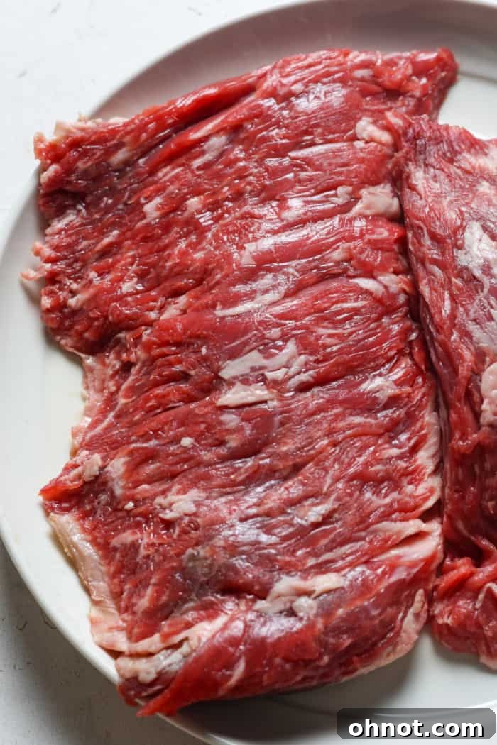 Raw skirt steak on a cutting board, ready for seasoning.