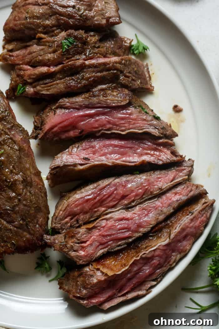 Thinly sliced skirt steak arranged beautifully with fresh herbs.