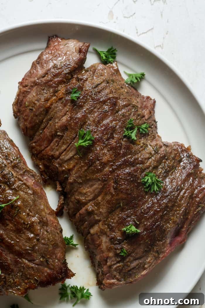 Sliced skirt steak garnished with fresh herbs, ready for serving.