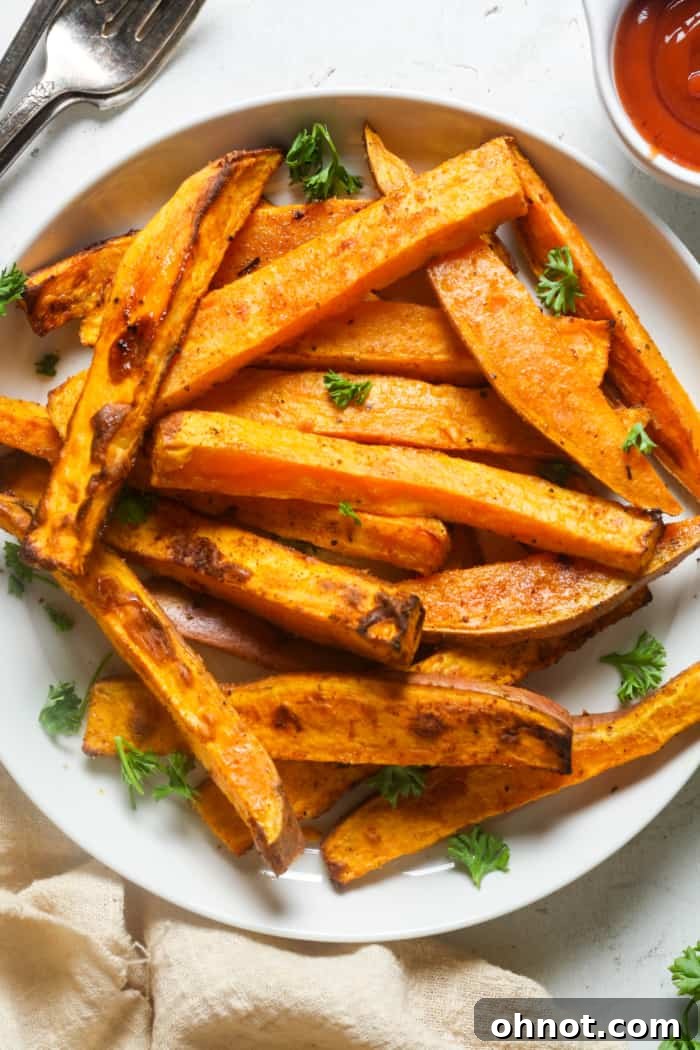 Crispy air fryer sweet potato fries arranged on a serving plate.