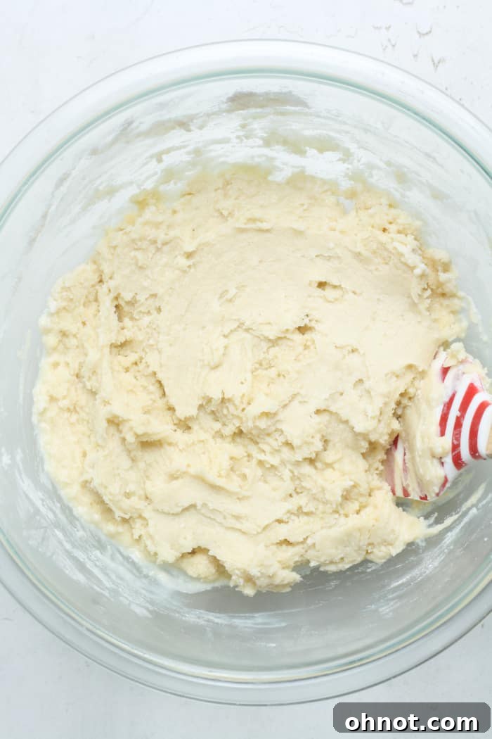 Thick, smooth coffee cake batter in a mixing bowl after flour and baking powder have been incorporated.