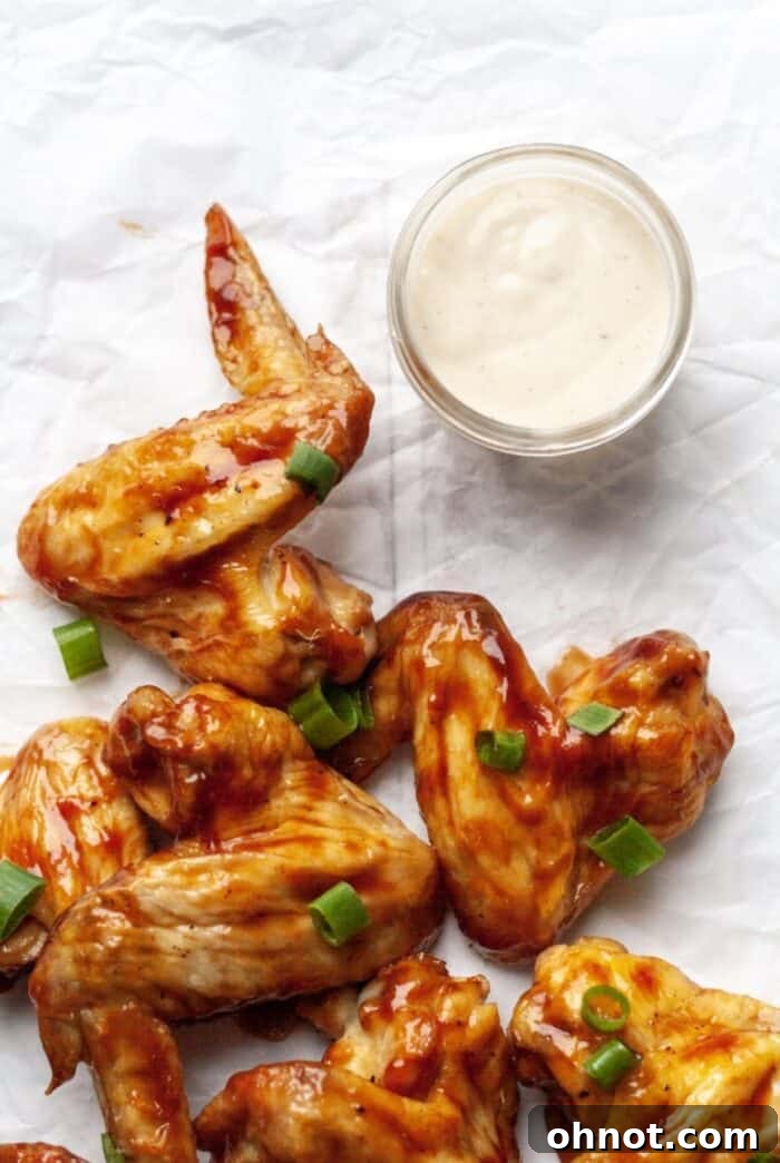 Whole30 air fryer chicken wings with BBQ sauce, garnished with green onions
