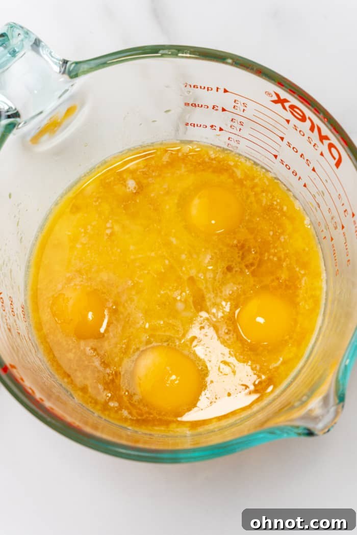 Eggs in large glass cup, ready to be whisked.