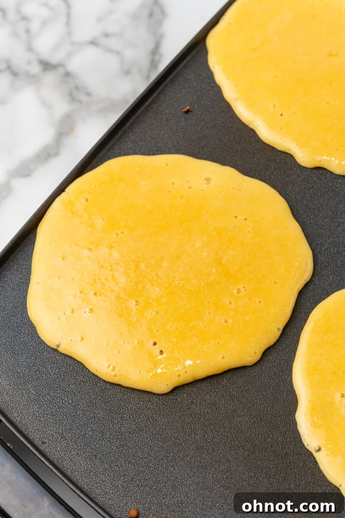 Low carb pancake batter being poured onto a hot skillet.