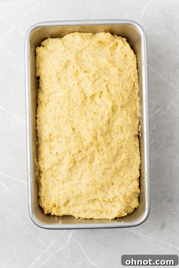 Risen gluten-free dough in a loaf pan.