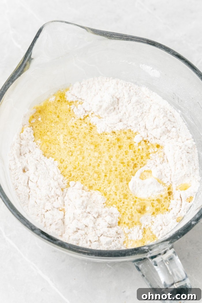 Wet ingredients being poured into dry ingredients.