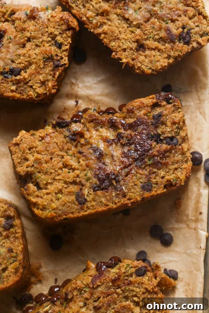A freshly baked loaf of healthy zucchini bread, sliced to reveal its moist interior with chocolate chips.