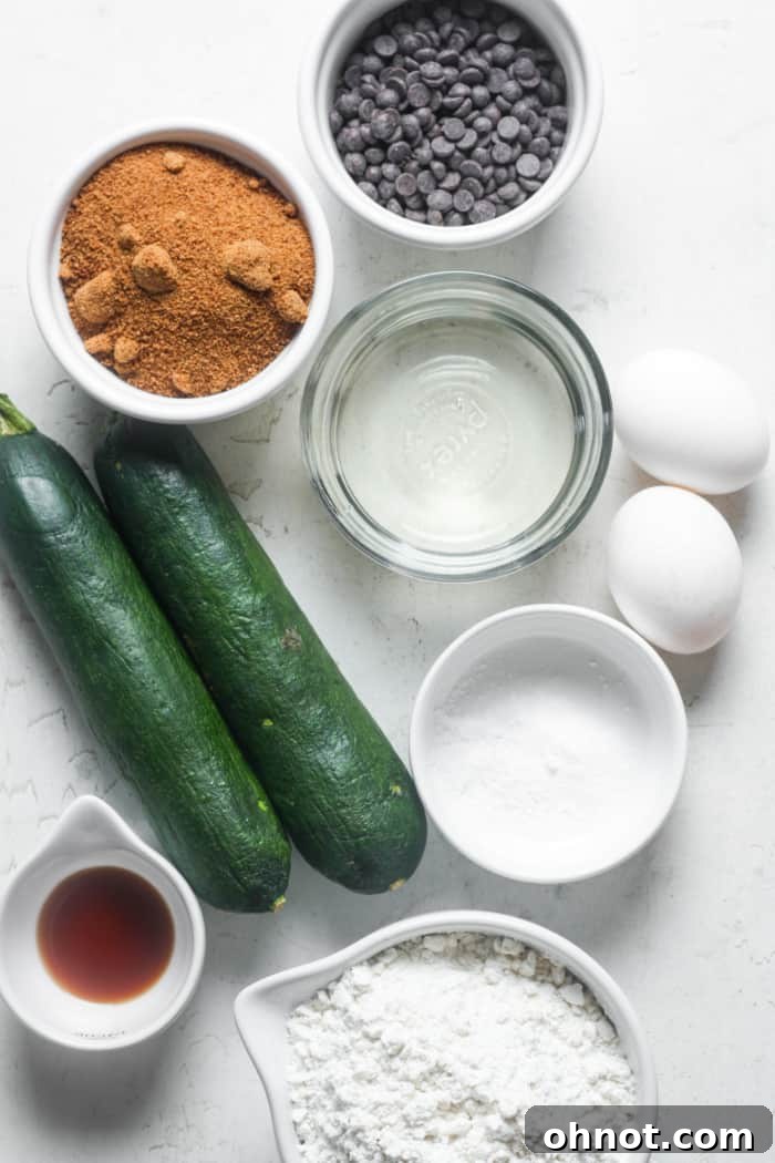 Various ingredients for healthy zucchini bread, including flour, sugar, eggs, and shredded zucchini.