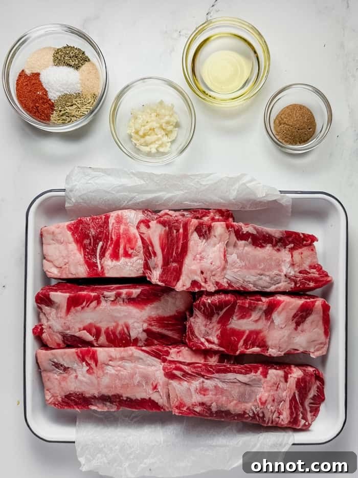 A collection of fresh garlic, olive oil, and various aromatic spices, essential for the beef back ribs recipe.