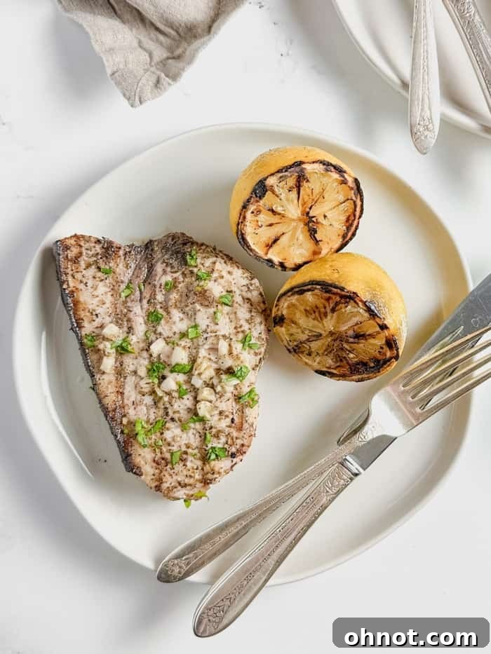 A close-up of a tender bite of swordfish on a fork.