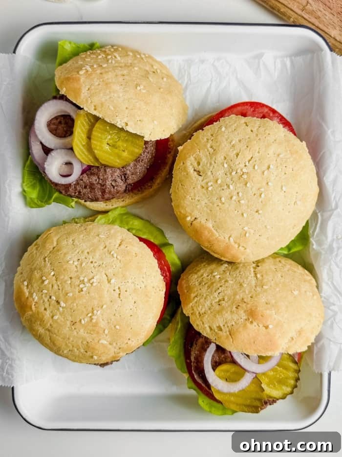 A platter of juicy burgers on gluten-free buns, accompanied by fresh toppings, ready to be served.