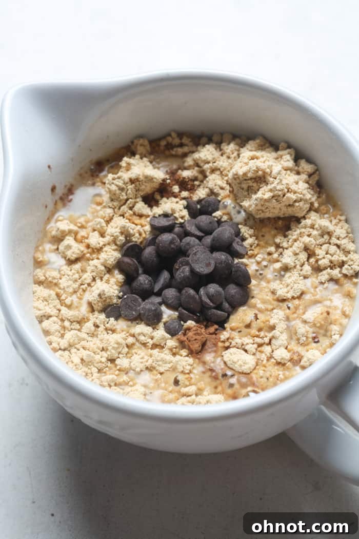 Dry and wet ingredients for protein mug cake mixed in a mug.