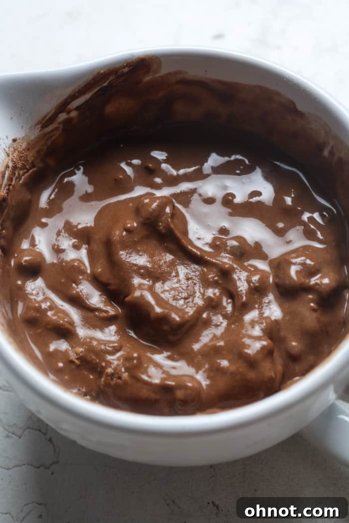 Smooth chocolate batter in a mug, ready for microwaving.