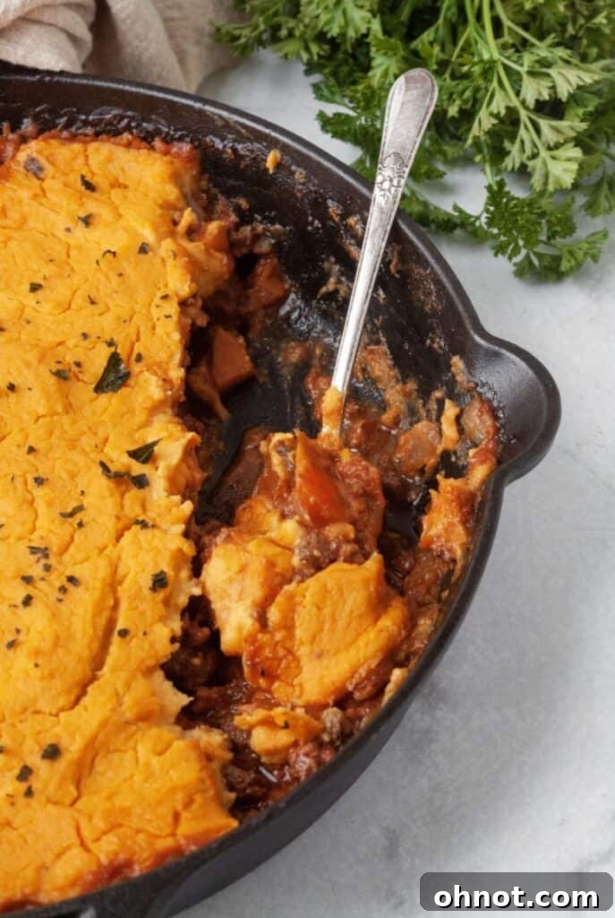 Close-up of Whole30 Shepherd's Pie with a golden sweet potato crust in a cast iron skillet.