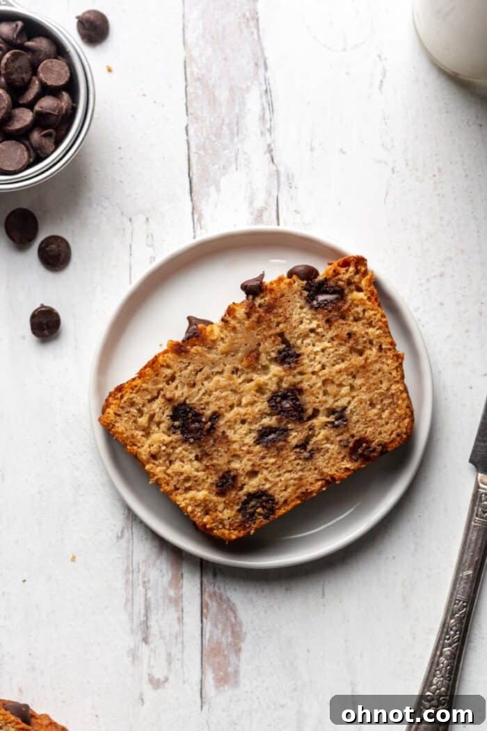 A slice of Paleo chocolate chip banana bread on a white plate, ready to eat