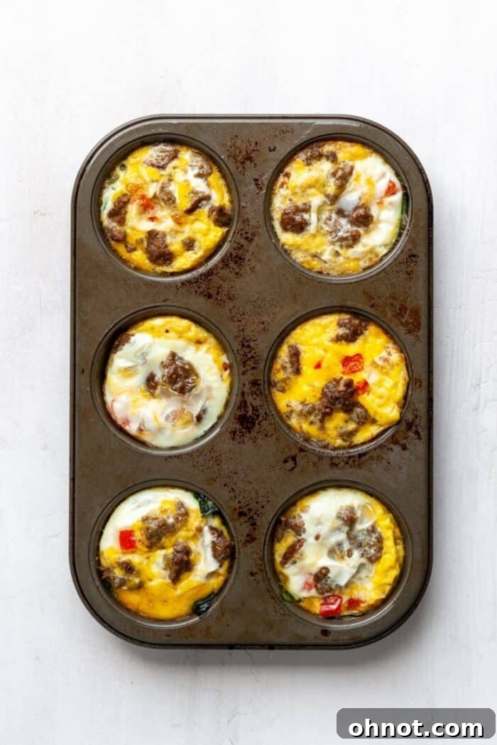 A baking tray filled with golden-brown Whole30 egg muffins, freshly baked and ready to be enjoyed.