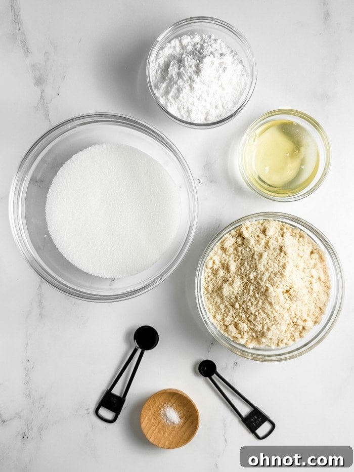 Organized ingredients for Amaretti cookies including almond flour, sugar, egg whites, and extracts.